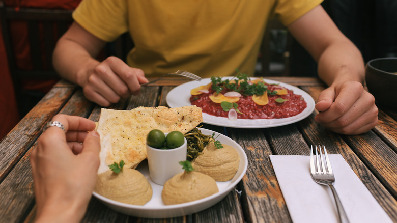 Couple sitting at table eating