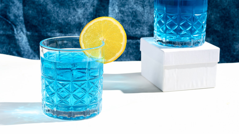 A blue cocktail in a glass cup