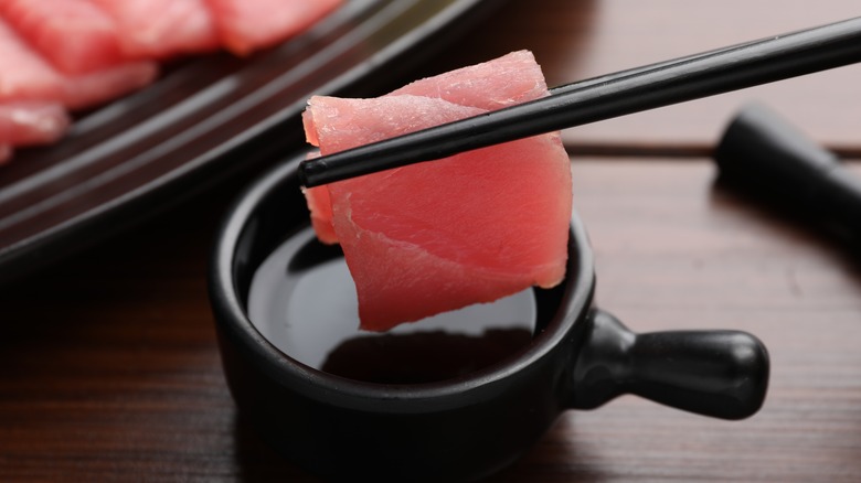 Dipping sashimi into shoyu