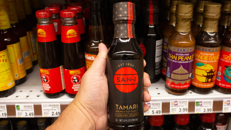 Person holding bottle of tamari shoyu