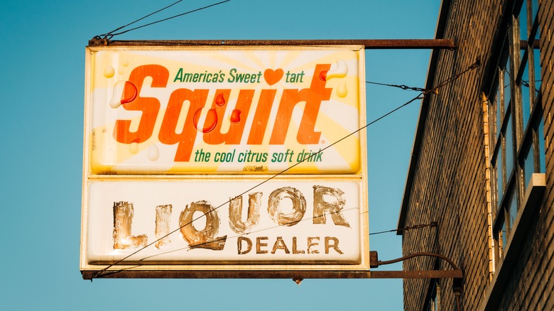 old squirt sign hanging from building