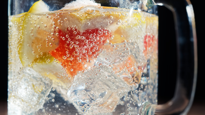 glass of soda with ice and grapefruit inside