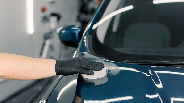 Man waxing blue car