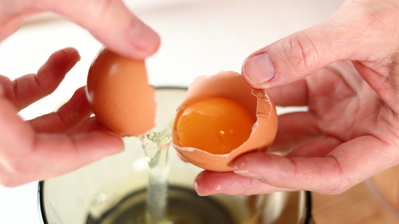 cracked brown egg removing egg whites from the yolkl