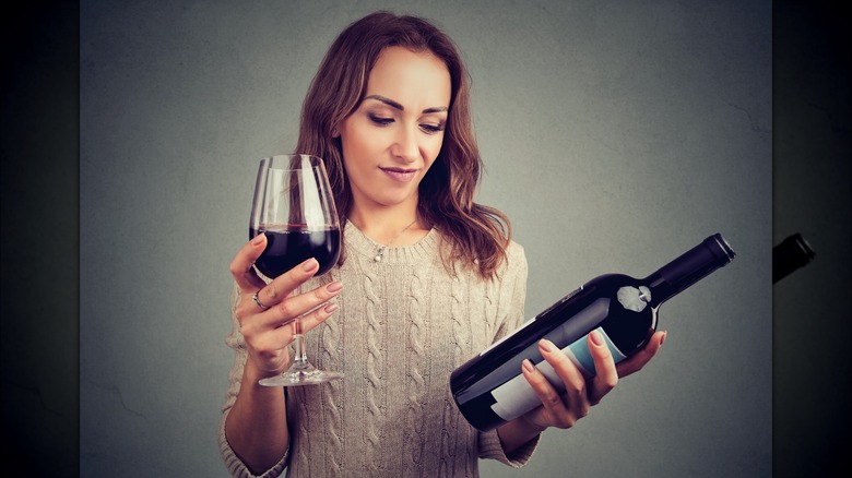 Woman eyeing bottle of wine