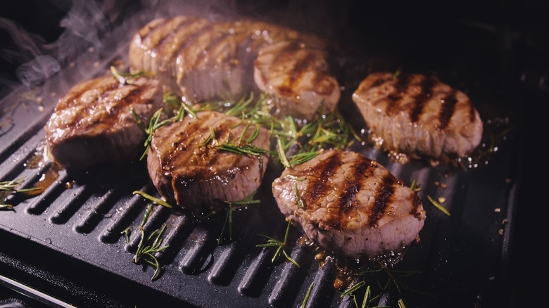 Steaks grilling with rosemary