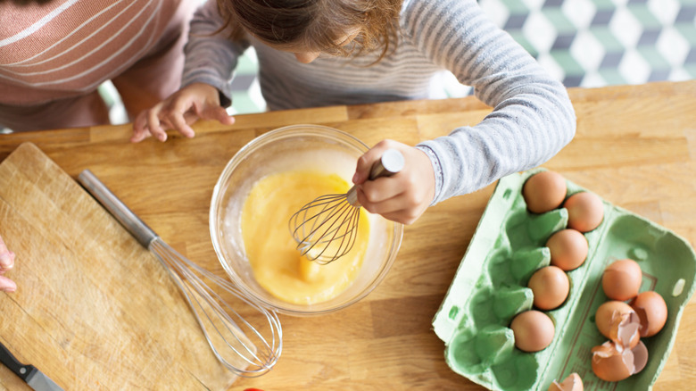 kid whisking eggs in bowl