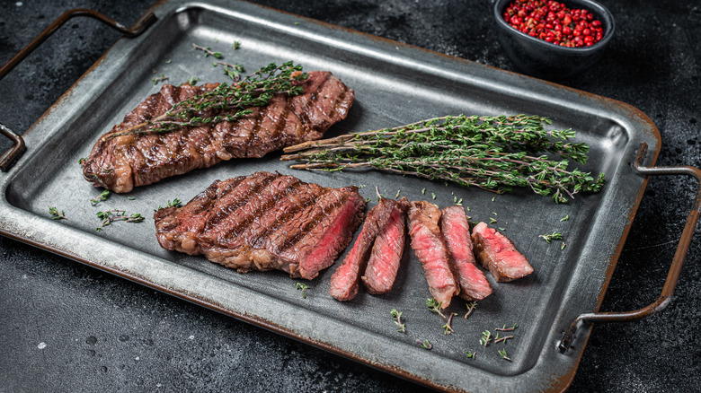 sliced steaks on a tray with rosemary