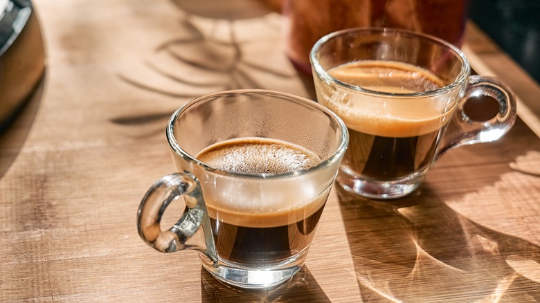 A ristretto next to an espresso, both in transparent small cups