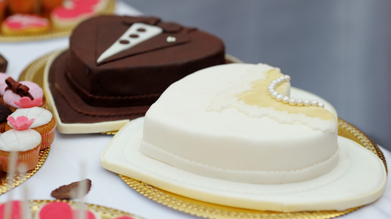 groom and bride's cakes sitting on a table