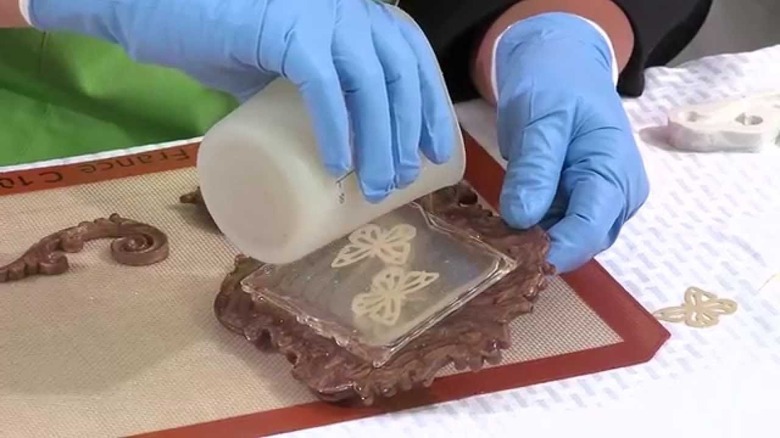 hands working on isomalt over a mat