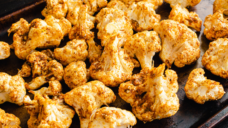 Cauliflower with curry on baking tray