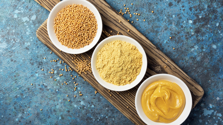 Bowls of mustard seed, mustard powder, mustard condiment