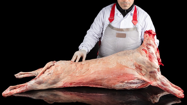 Butcher processing a sheep carcass