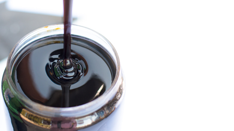 Molasses pouring into a jar