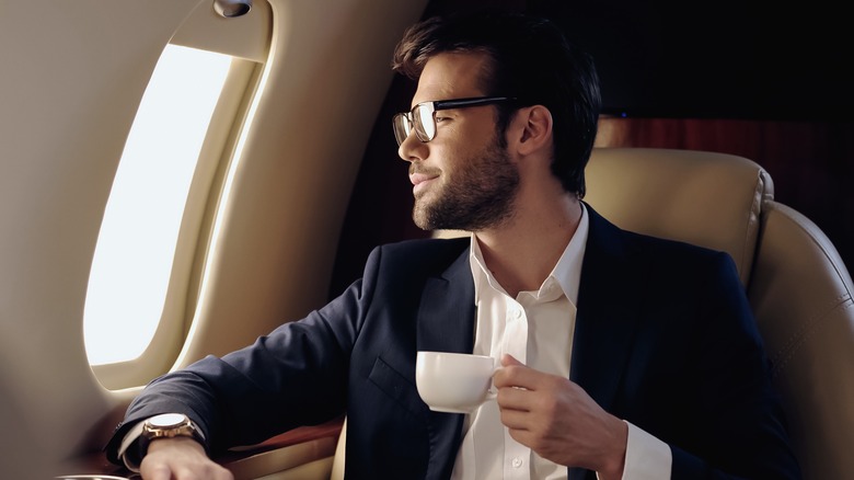 Man drinking coffee on plane