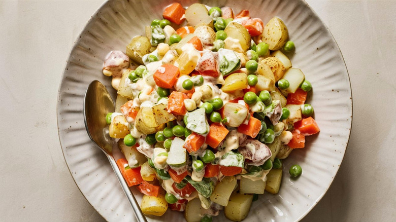 Plate of Russian egg salad, with spoon balanced on the edge of the dish