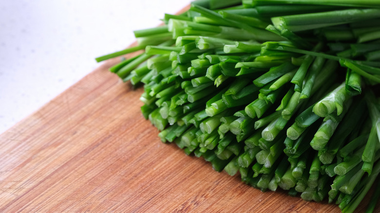 Sliced garlic chives on wooden board