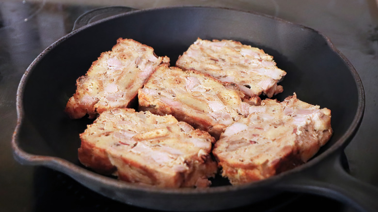 Scrapple frying in cast-iron pan