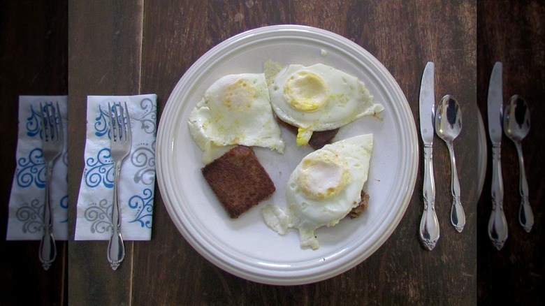 Scrapple with eggs on white plate