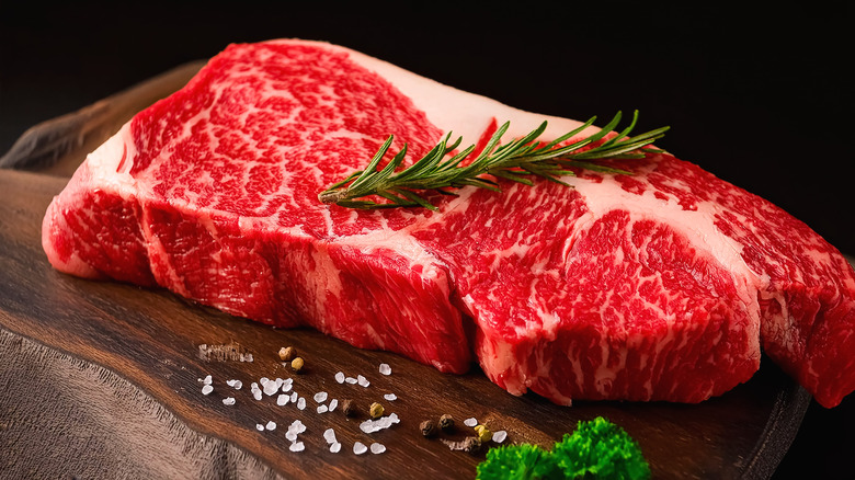 A well-marbled steak placed on a wooden table