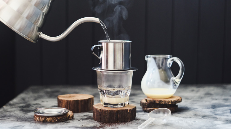 Water pours from a kettle into a cup