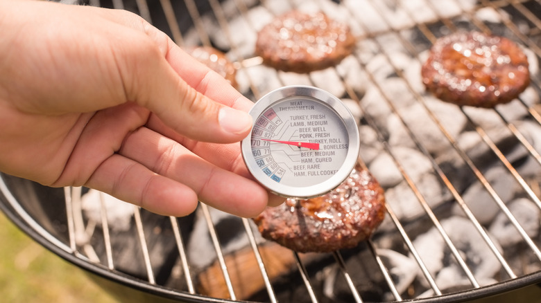 Checking burger patty with thermometer