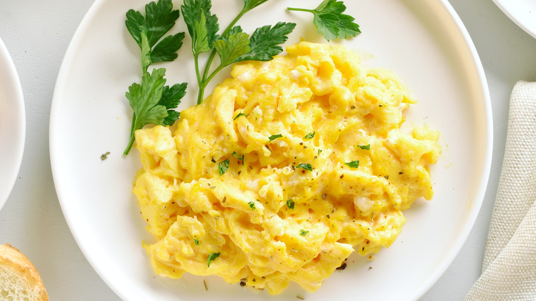 Scrambled eggs finished with salt, pepper, and herbs