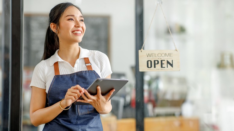 smiling waitress in restaurant holding a tablet