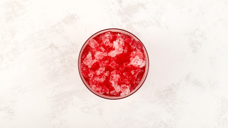 top down view of cup of red syrup and ice