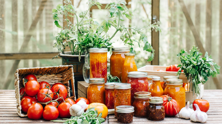 Tomato jam and tomatoes on table