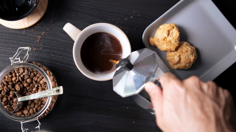 Person pouring coffee from a moka pot