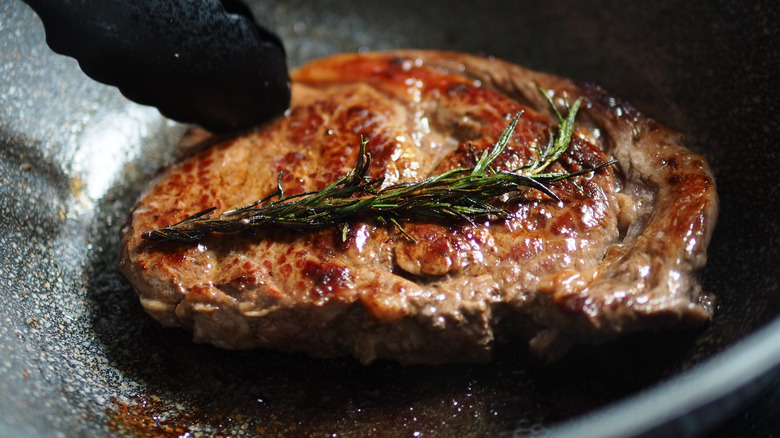 steak in a pan cooking