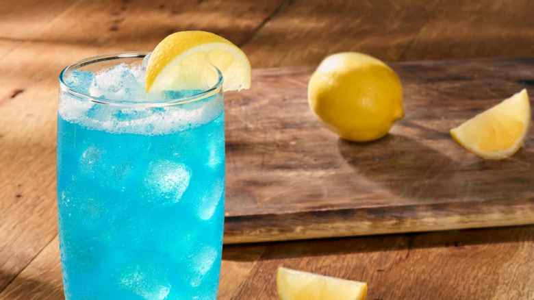 A Blue Amalfi cocktail with lemon wedges