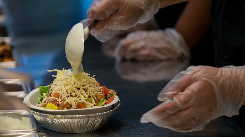 Chipotle employee makes burrito bowl