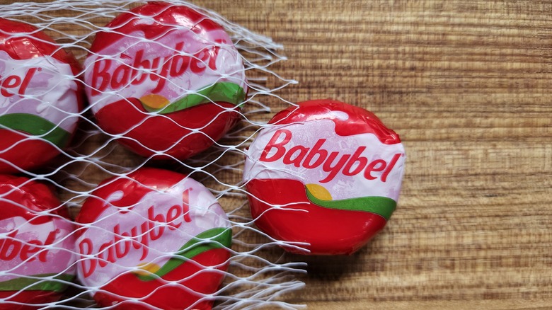 Bag of Babybel cheese wheels on a wood background