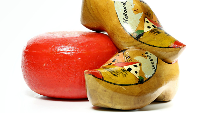 Wheel of red wax encased cheese with Dutch wooden clogs