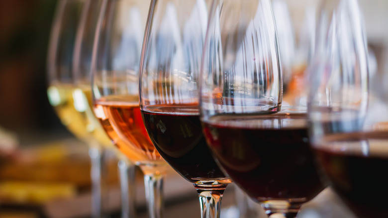 Line of wine glasses filled with red, white and rose wines