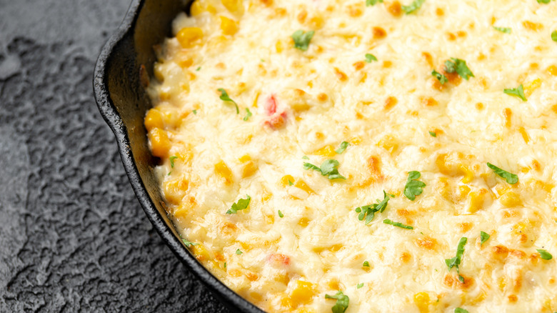 Close on skillet full of cheesy corn