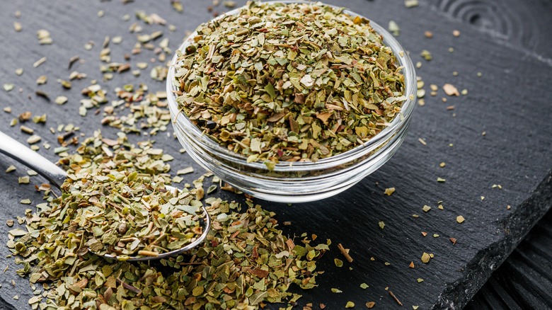 dried oregano in bowl and on table