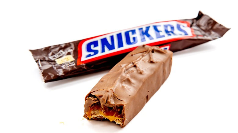 opened Snickers on white backdrop