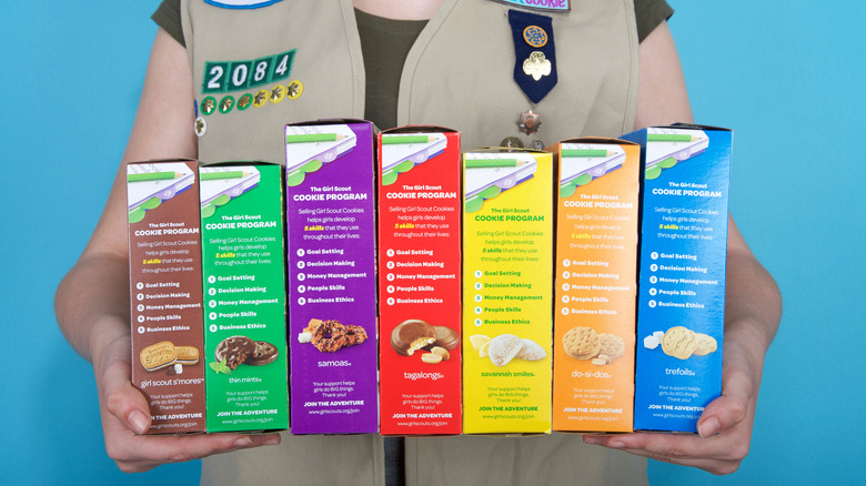 Girl Scout holding cookie boxes