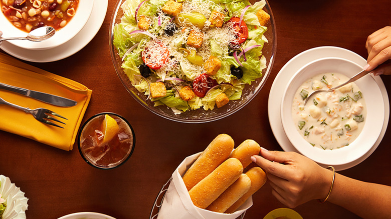 olive garden salad served with breadsticks and soup