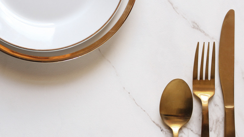 gold-rimmed plate fork spoon knife