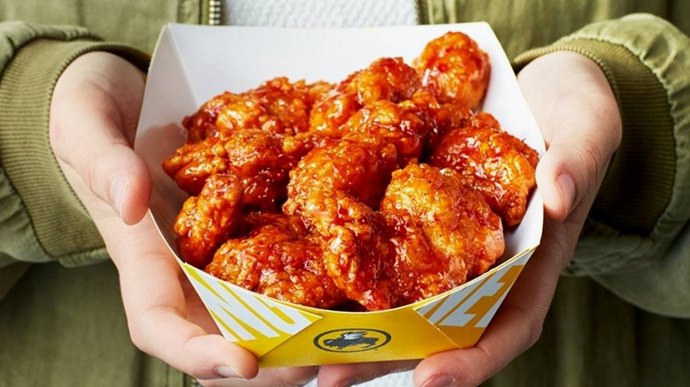 person holding a container of boneless wings from Buffalo Wild Wings