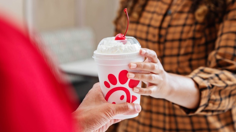 Chick-fil-A milkshake being passed from employee to customer