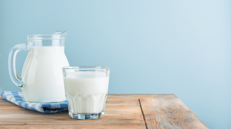 A pitcher and a glass of milk on a table