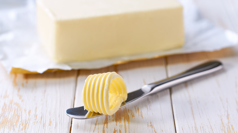 A knife with a roll of butter