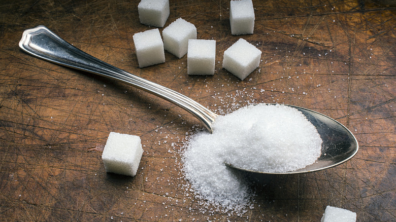 A spoonful of sugar and sugar cubes on a table