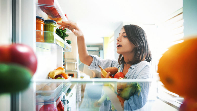 Person getting food in refrigerator